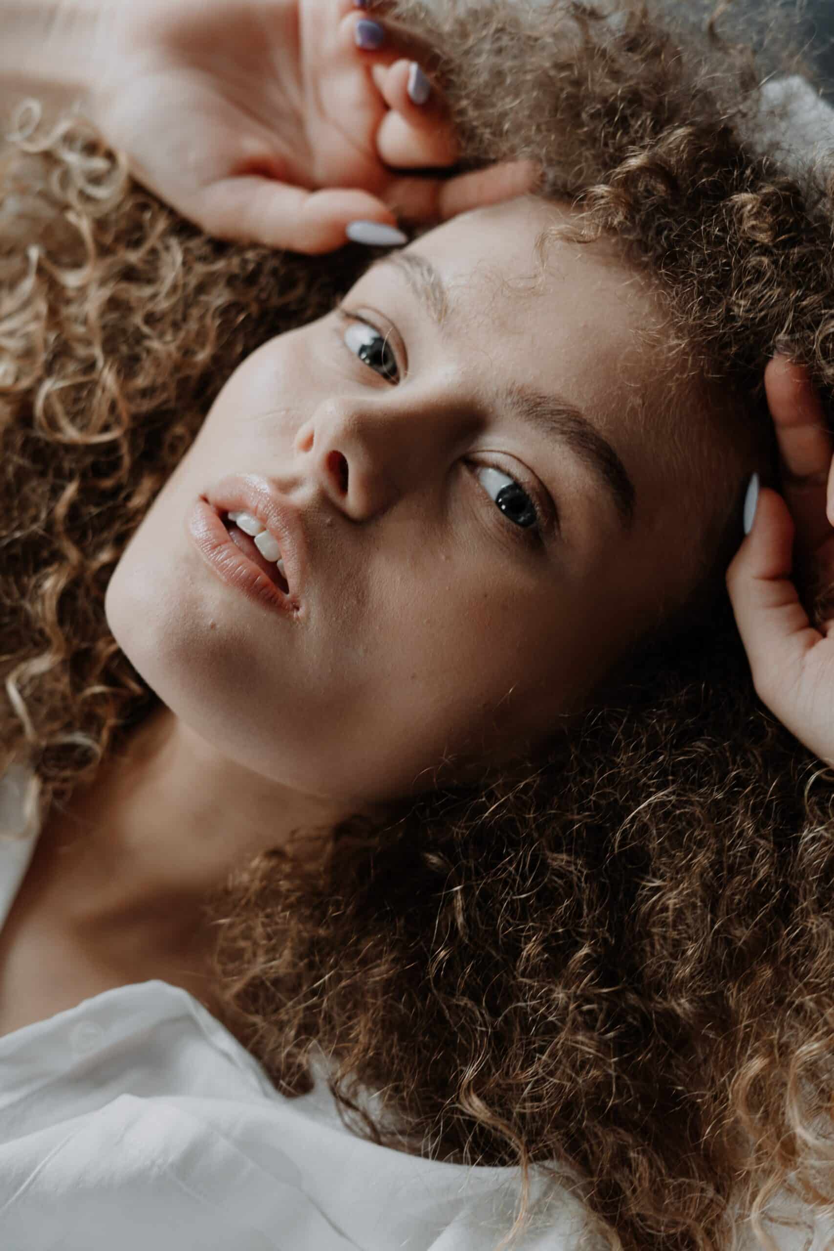 woman with hands in her curly hair