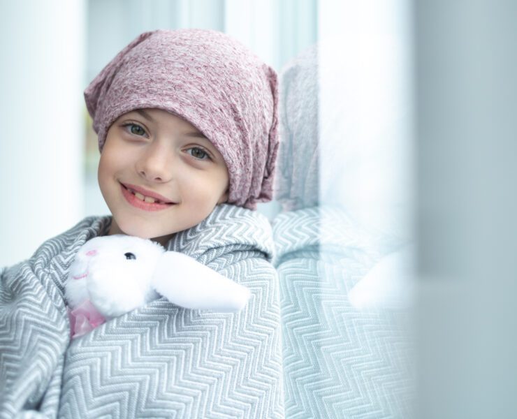 girl with cancer holding a stuffed toy