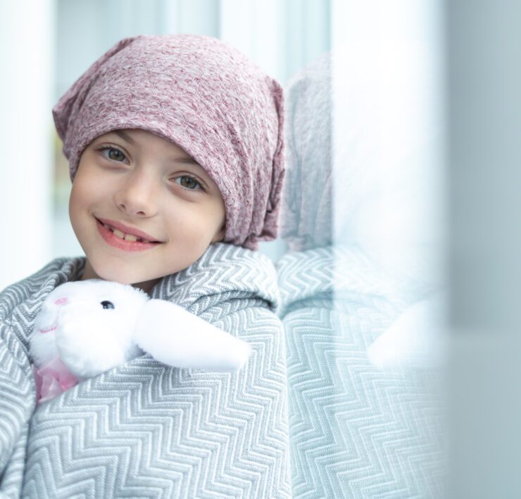 girl with cancer holding a stuffed toy