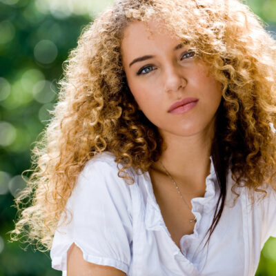 A beautiful young woman with great curly hair outside